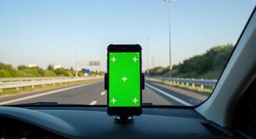 Smartphone with green screen in car holder for navigation and entertainment photo