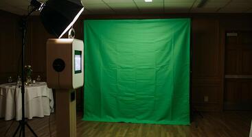 Photo booth setup with green screen backdrop for events or studio use