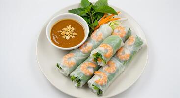 Delicate shrimp spring rolls with peanut sauce on a pristine white background photo