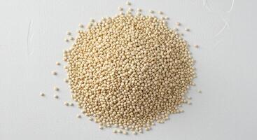 A top down view showcases a generous mound of quinoa, perfectly arranged on a white backdrop. photo