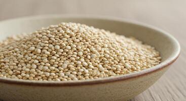 A close up view of a bowl filled with uncooked quinoa grains ready for cooking. photo