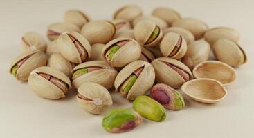 An appetizing collection of pistachios, some opened, displaying the delicious green nut. photo