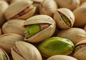 A macro shot reveals a pile of fresh, appetizing pistachios with open shells. photo