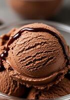 A macro shot presents a scoop of chocolate ice cream topped with a rich chocolate drizzle. photo