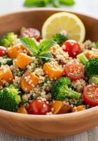 A colorful and nutritious quinoa salad with a medley of fresh vegetables served in a wooden bowl. photo