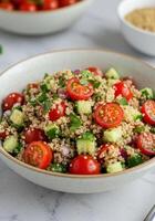 A healthy and delicious quinoa salad with fresh tomatoes and cucumbers, ready to enjoy. photo