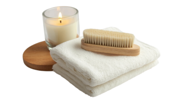 Relaxation setup featuring a candle, towels, and a wooden brush for a calming experience at home png
