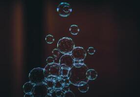 A cluster of soap bubbles, showcasing iridescent colors, rising and floating in the air. photo