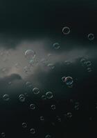 Numerous shimmering bubbles float gracefully in the air against a backdrop of a dark, cloudy sky. photo
