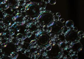 A mesmerizing arrangement of connected soap bubbles with rainbow reflections. photo