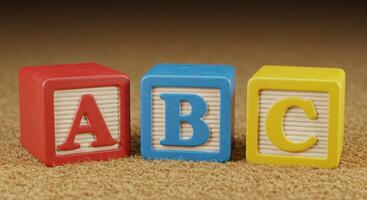 Three wooden alphabet blocks displaying the letters a, b, and c, arranged together in a row. photo