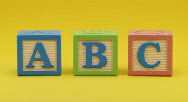 Three colorful wooden blocks displaying the first three letters of the alphabet. photo