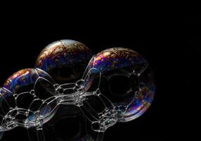 Vibrant soap bubbles exhibit intricate patterns in a close-up shot against a black background. photo