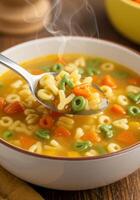 A delicious and warm bowl of alphabet soup with carrots and letters on a spoon. photo