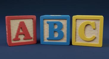 Wooden blocks displaying the alphabet letters a, b, and c on a dark blue background. photo