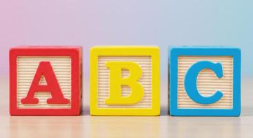 Close-up of three wooden blocks, each displaying a letter of the alphabet for education. photo