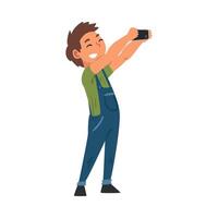 Smiling Boy in Overalls Taking Selfie Photo, Cute Child Character Photographing Himself with Smartphone Cartoon Illustration vector