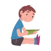 Boy Sitting on the Floor and Playing with Paper Airplane, Cute Child Daily Routine Activity Cartoon Style Illustration on White Background vector