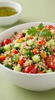 A refreshing quinoa salad with colorful vegetables in a white bowl, ready to eat. photo