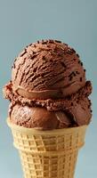 A close up of chocolate ice cream scoops with sprinkles in a waffle cone. photo