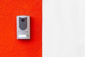 Modern door intercom on red and white wall photo