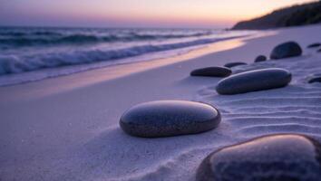 Smooth Stones on Sandy Beach at Dusk with Gentle Ocean Waves photo