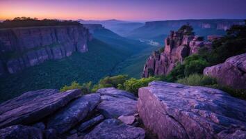 Dramatic Rock Formation Overlooking Green Valley with Colorful Sky at Dusk photo