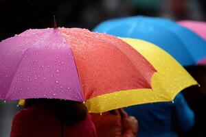 People protecting from rain with colorful umbrellas photo
