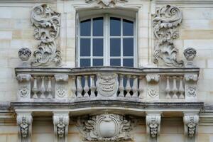 Elegant stone balcony with ornate sculptures and window enhancing a building's facade photo