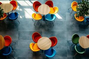 Colorful chairs and round tables creating a vibrant and modern cafeteria space photo