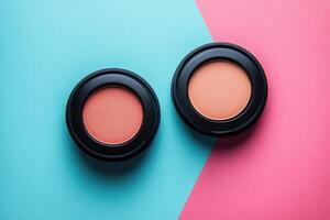 Two round containers of blush resting on a two toned surface photo