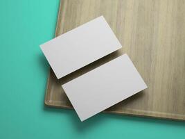 Blank business cards with subtle shadow on cornered tray and teal background. photo