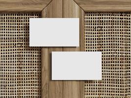 Mockup of two business cards placed on a natural rattan background with a clean wood frame for a minimalist design. photo
