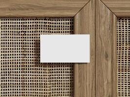Business card mockup on a woven rattan background, showing a single blank card with wood framing for a professional presentation. photo