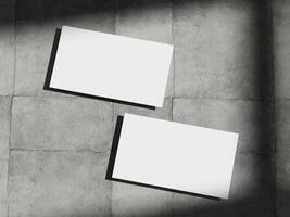 Professional business card mockup on a concrete background, featuring subtle shadows and a minimalist aesthetic. photo