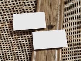 Elegant business card mockup with two blank cards on a rattan surface, framed by a wooden border for a minimalist and professional touch. photo