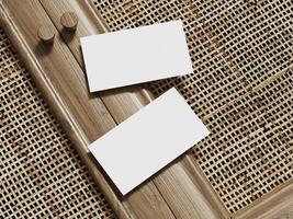Business card mockup on a woven rattan background, with two blank cards framed in wood for a clean and sophisticated look. photo