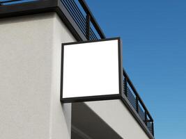 Minimalistic blank logo sign mockup with a modern square frame hanging on a building's wall. photo