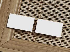 Business card mockup with two cards on a rattan texture backdrop, framed with wood for a refined and simple presentation. photo