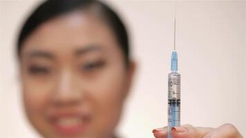 Doctor preparing an injection with a syringe, smiling confidently video