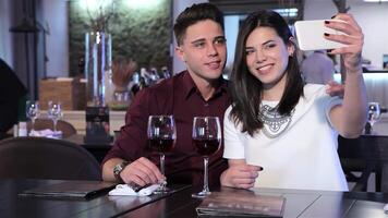 Couple takes a joyful selfie at a cozy restaurant video