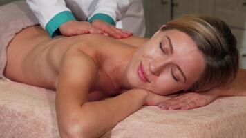 Radiant woman beaming while enjoying a rejuvenating full body massage video
