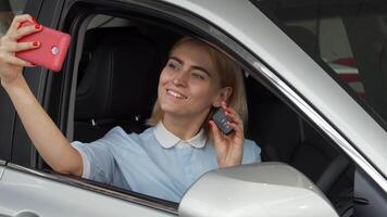 Joyful female driver capturing selfies with her car keys in hand video