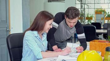 Smiling female architect collaborates with her colleague on blueprints video