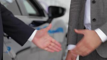Hands shaking in front of a sleek car video
