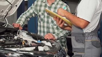 Mechanic discussing car issues while filling out paperwork video