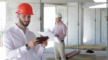 Confident architect examines digital tablet on construction site video