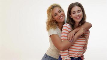 Two joyful girlfriends embracing and smiling brightly video