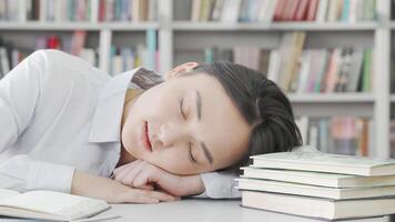 Exhausted female student dozing off at her desk after intense studying video