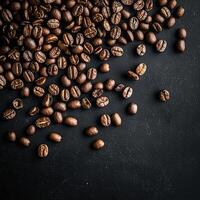 A close-up shot captures the rich, dark roasted coffee beans on a textured black surface. photo